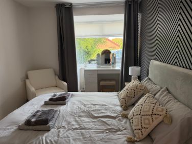 Bedroom one featuring: - Double bed - Acoustic wall panelling - Bedside cabinets with LED lighting -