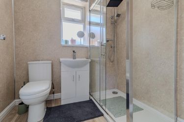 Main bathroom featuring WC, wash hand basin with vanity unit, walk-in shower with twin shower heads