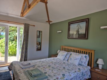 Large downstairs bedroom, doors open to private patio