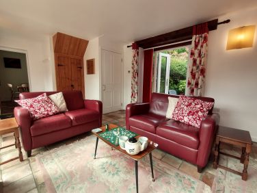 Lounge area with doors to patio and upstairs