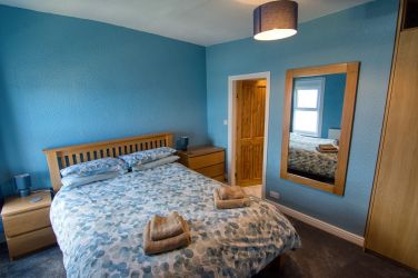 The master bedroom with a king sized bed and ensuite bathroom