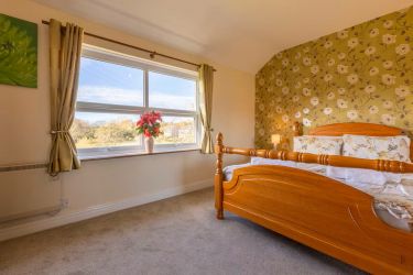 Master Bedroom with ensuite shower room - Beautiful view across field to rear of property.
