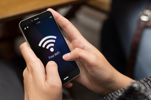 Person holding an iPhone displaying the wifi signal
