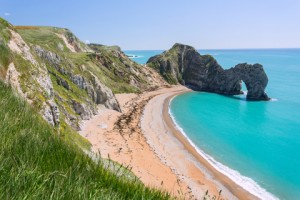 Sandy beach, turquoise water & Lulworth Cove as a backdrop