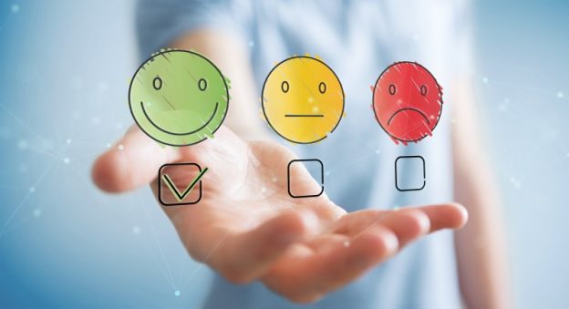 Three cartoon faces, a green one smiling, a neutral expression on yellow one and a red face frowning