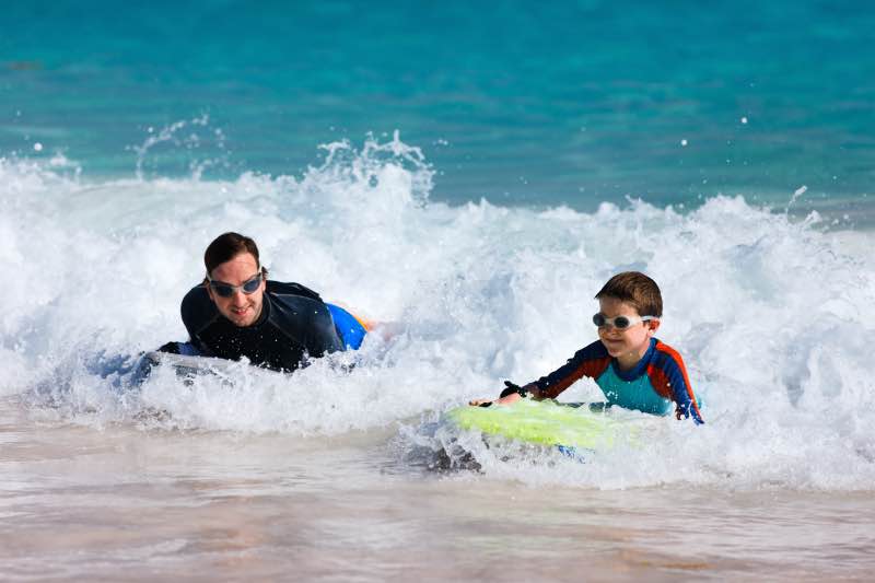 Father and son riding the waves on body board