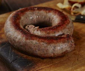 Cumberland sausage on a wooden board with onions