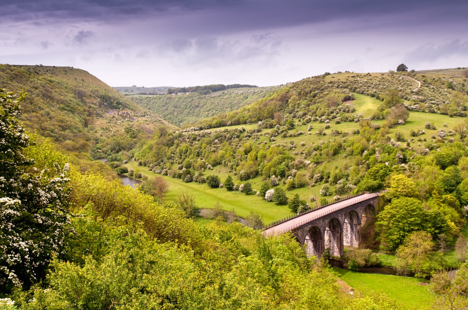 Viaduct bridge cutting through green rolling countryside
