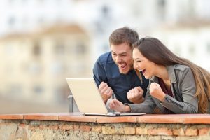 Couple excited looking at laptop