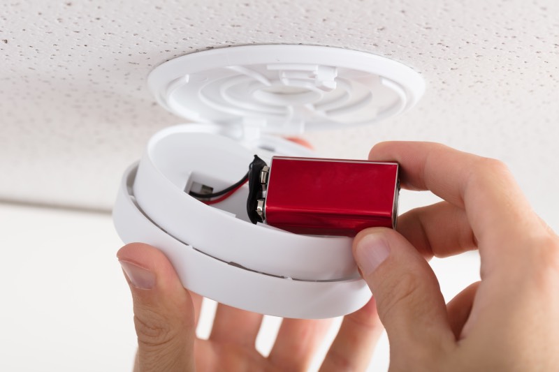 Batteries of a smoke detector being changed