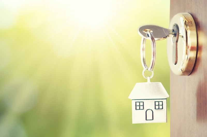 A key in a door with a cottage shaped keyring.